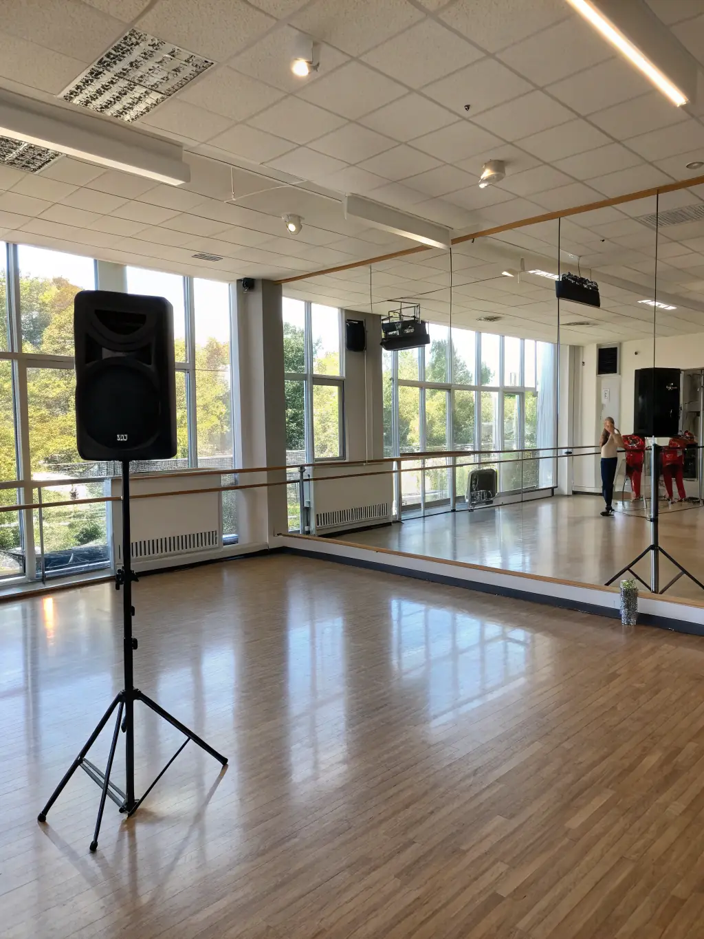A brightly lit rehearsal studio with dancers practicing, showcasing 2117's support for performing arts.